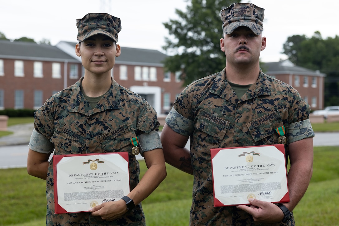 U.S. Marine Corps Sgt. Michelle Lescano, left, and Lance Cpl. Colton Richardson, right, both military police officers with Headquarters and Support Battalion, Marine Corps Installations East-Marine Corps Base (MCB) Camp Lejeune, are awarded the Navy and Marine Corps Achievement Medal  on MCB Camp Lejeune, North Carolina, Aug. 26, 2022. Lescano and Richardson were awarded the Navy and Marine Corps Achievement Medal for saving the life of another Marine during a dispatch call on May 19, 2022. (U.S. Marine Corps photo by Cpl. Makayla Elizalde)