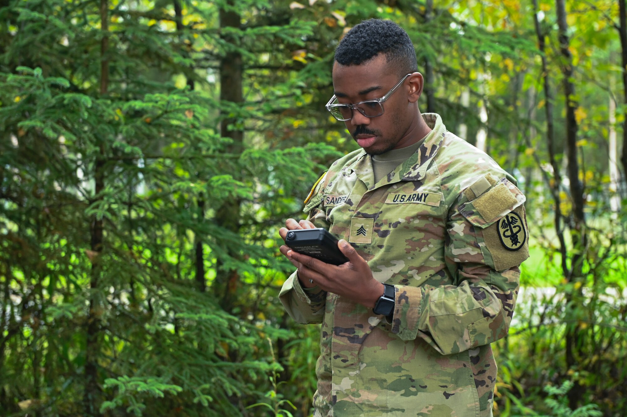 U.S. Army Sgt. Joshua Sanders uses a small device in his hands