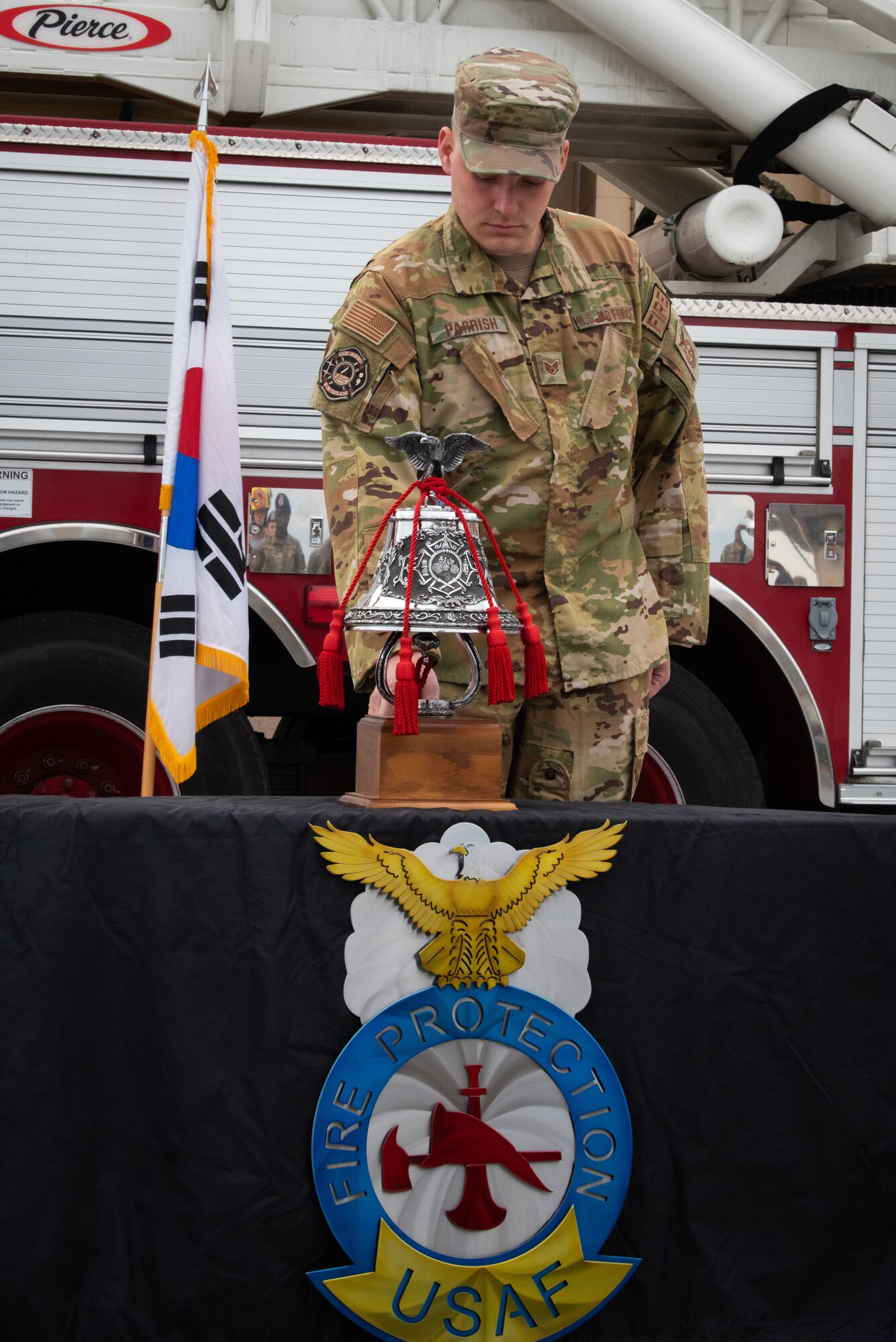 Staff Sgt. Logan Parrish, 51st Civil Engineer Squadron fire inspector, rings the fire station bell during a 9/11 Remembrance Ceremony at Osan Air Base, Republic of Korea, Sept. 10, 2022.