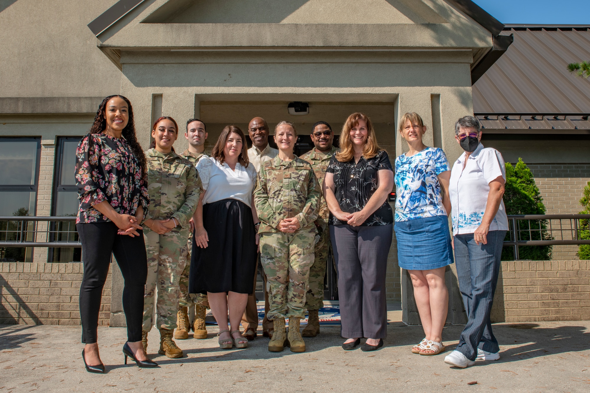 Members of the 512th and 436th airlift wings pose for a photo outside the Military & Family Readiness Center, at Dover Air Force Base, Delaware, Aug. 7, 2022. Previously known as the Airman & Family Readiness Center, the Air Force renamed the MFRC to be more inclusive to all members of the military and their families. The MFRC mission is to provide individuals, families and leadership with programs that promote self-sufficiency and enhance mission readiness, retention and adaptation to the Air Force way of life.
