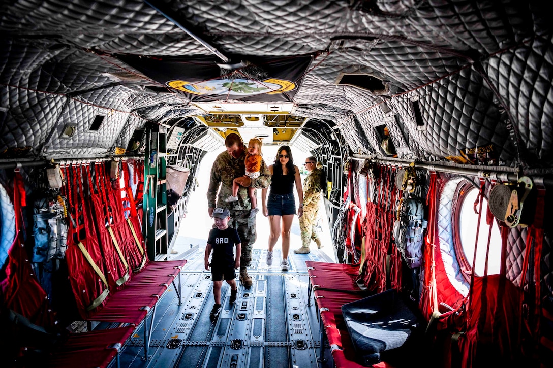 An airman and his family walk inside an aircraft.