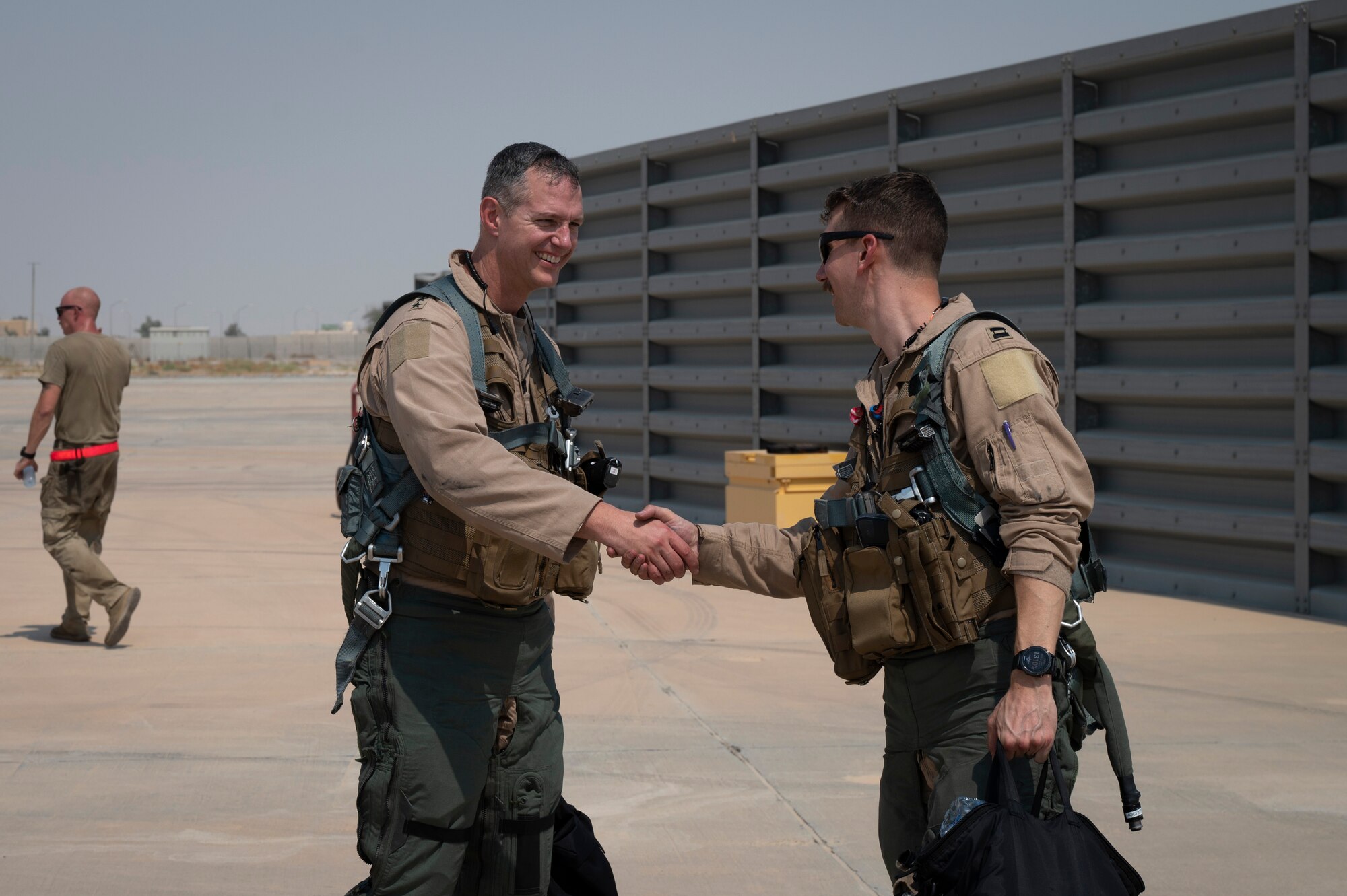 U.S. Air Force Lt. Gen. Alexus Grynkewich, Ninth Air Force (Air Forces Central) commander, shakes the hand of Capt. Sean Cahill, 79th Expeditionary Fighter Squadron F-16CM Fighting Falcon pilot, after flying a mission together at an undisclosed location, September 7, 2022. Grynkewich flew an F-16 Fighting Falcon alongside AFCENT Airmen and coalition partners in support of Operation Inherent Resolve as part of Operation Agile Spartan III. OAS III tested rapid troop and equipment movement to and from dispersed locations around the U.S. Central Command area of responsibility.(U.S. Air Force photo by Staff Sgt. Dalton Williams)