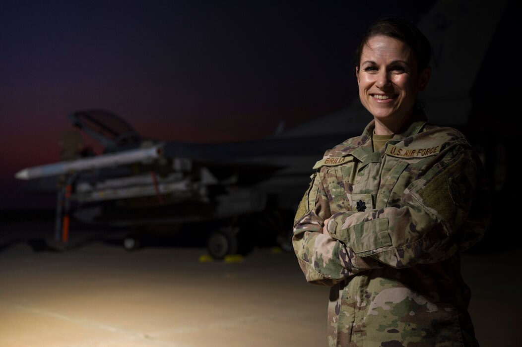 U.S. Air Force Lt. Col. Erin Brilla, 386th Air Expeditionary Wing/A5X Plans and Programs Director, poses for a photo next to a F-16CM Fighting Falcon during an exercise at an Undisclosed Location, September 12, 2022. Brilla acted as the lead planner at a dispersed location during Operation Agile Spartan III, ensuring supported to the dislocated assets and personnel. Operation Agile Spartan III was Ninth Air Force (Air Forces Central)'s third agile combat employment capstone event, testing wings' ability to execute rapid troop and equipment movement. (U.S. Air Force photo by Staff Sgt. Dalton Williams)