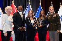 Col. Paige M. Jennings, U.S. Army Financial Management Command commander, right, presents Navy Federal Credit Union at U.S. Army Garrison Fort Meade with the Army Distinguished Credit Union Service Award in San Antonio Aug. 2, 2022. Posing with Jennings are Mary A. McDuffie, Navy Federal Credit Union president and chief executive officer; Keith Hoskins, NFCU executive vice president of branch operations; Jenelle Taylor, NFCU regional manger; and Coleen Collins, NFCU Fort Meade branch manager. (Photo by Alexandra Aleman)