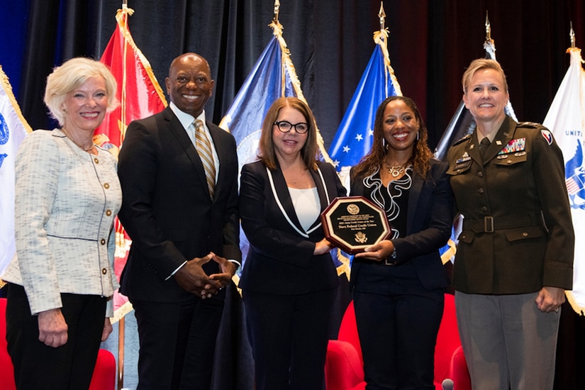 Col. Paige M. Jennings, U.S. Army Financial Management Command commander, right, presents Navy Federal Credit Union at U.S. Army Garrison Fort Meade with the Army Distinguished Credit Union Service Award in San Antonio Aug. 2, 2022. Posing with Jennings are Mary A. McDuffie, Navy Federal Credit Union president and chief executive officer; Keith Hoskins, NFCU executive vice president of branch operations; Jenelle Taylor, NFCU regional manger; and Coleen Collins, NFCU Fort Meade branch manager. (Photo by Alexandra Aleman)
