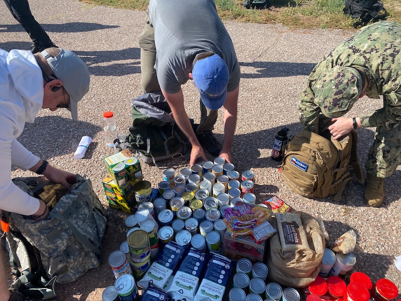 Participants from the "Ruck 4 A Reason" unload non-perishable donations for the Peterson Food Pantry during a Suicide Prevention and Awareness Month event hosted at Peterson Space Force Base, Colo., Sept. 9, 2022.