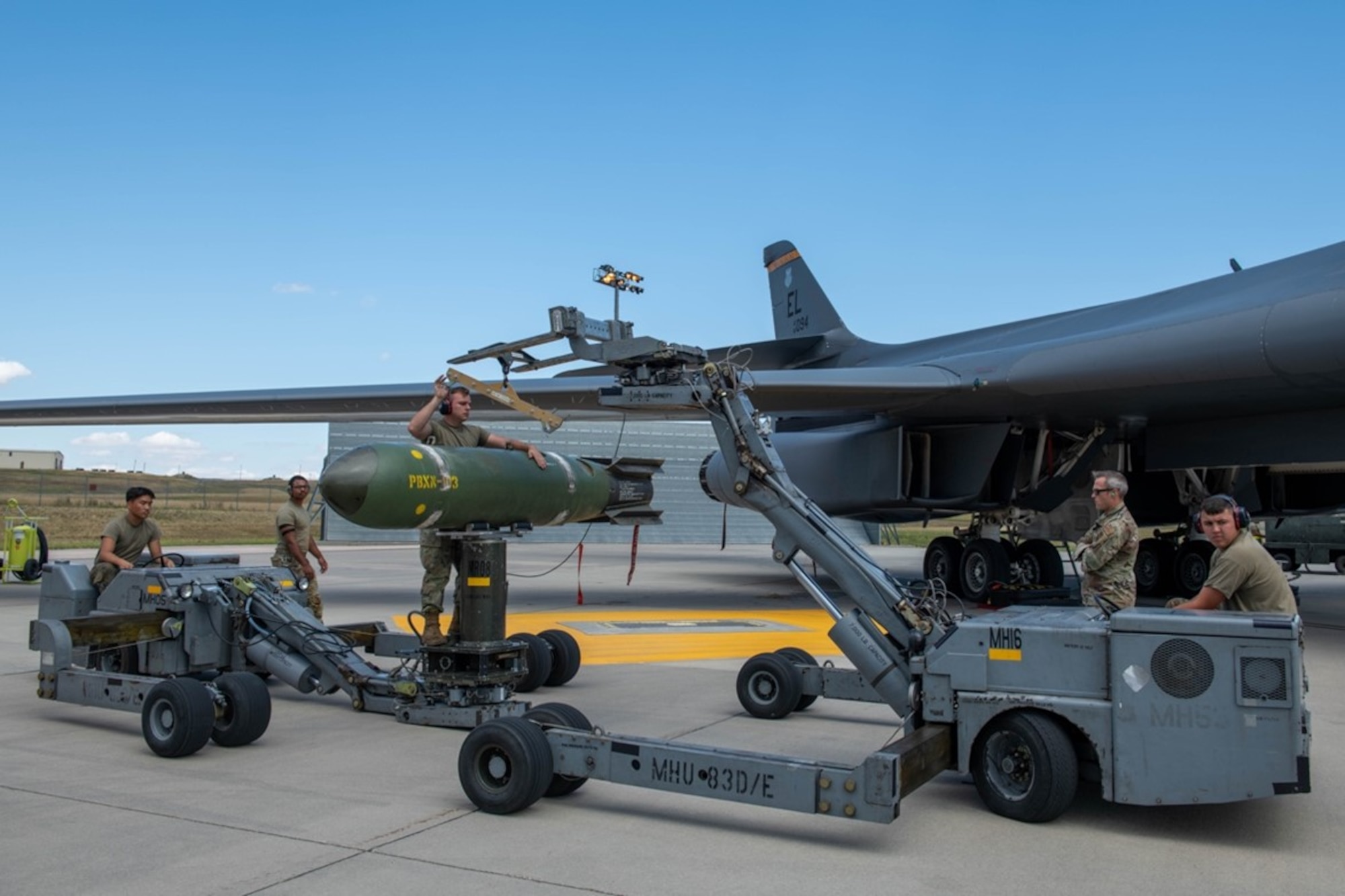 Load crew members from the 28th Aircraft Maintenance Squadron transport a Mark-65 Quickstrike mine at Ellsworth Air Force Base, S.D., Aug. 24, 2022. The Quickstrike is a family of shallow-water, aircraft-laid mines and the Mark-65 is a 2,000-pound mine used against surface and subsurface craft. (U.S. Air Force photo by Senior Airman Quentin K. Marx)