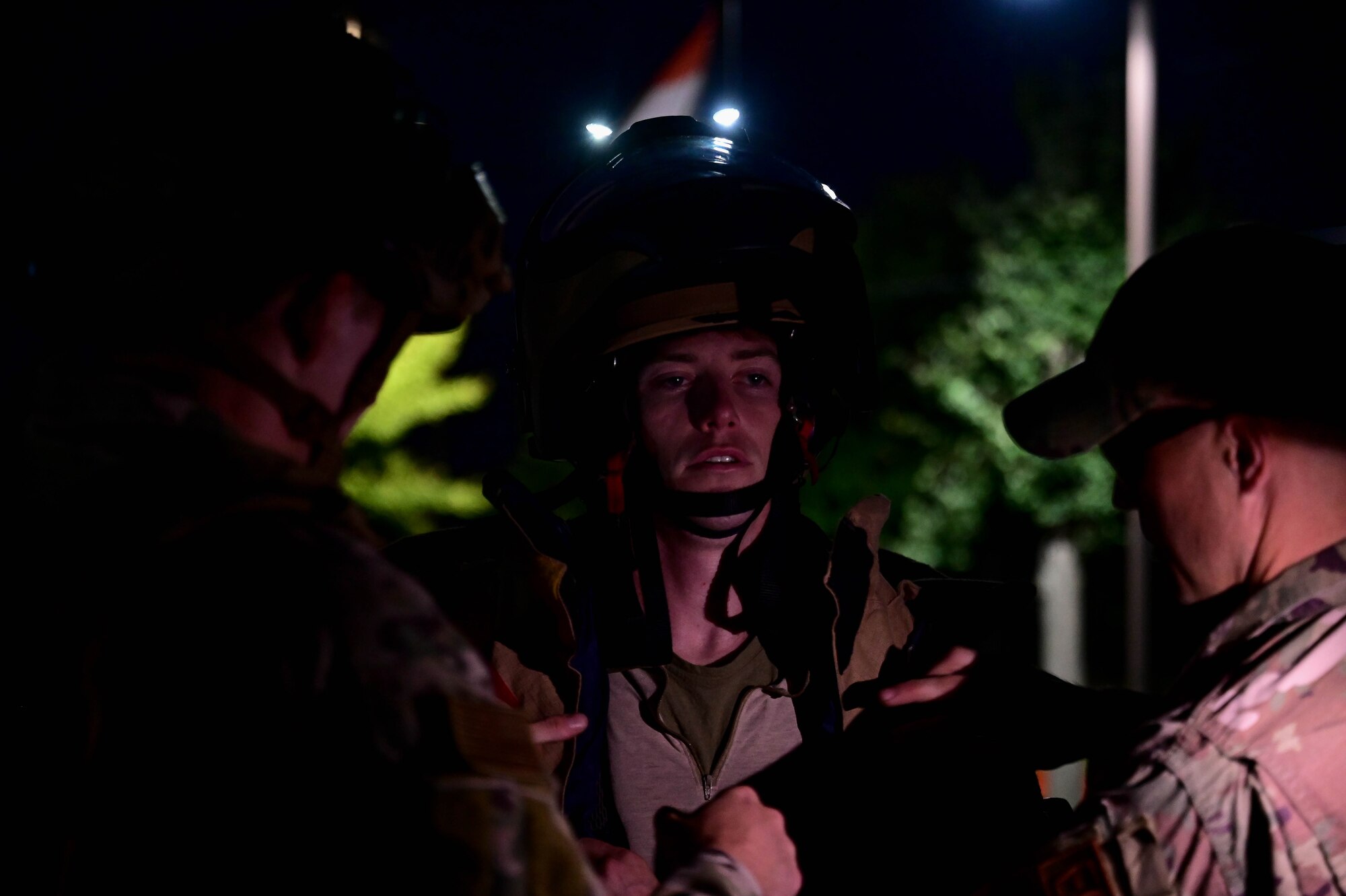 Man is helped to dress in bomb suit.