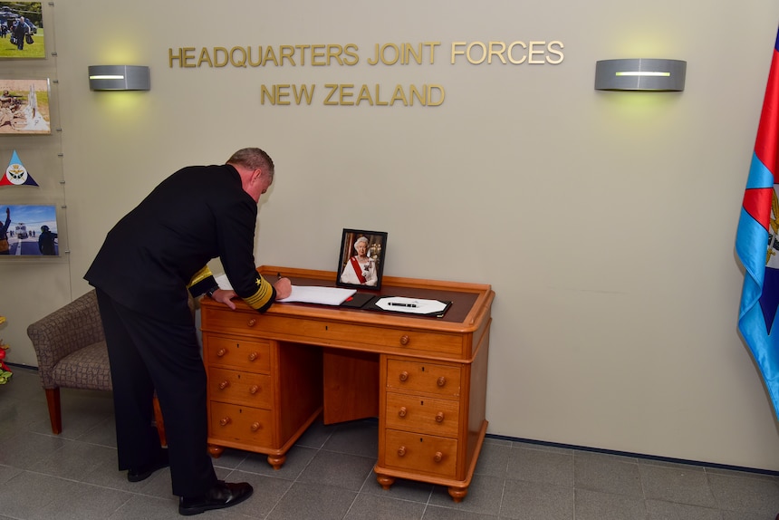 Adm. Samuel Paparo writes a condolence to Her Majesty, Queen Elizabeth II, and to the people of New Zealand and all Commonwealths during a visit to Joint Forces New Zealand headquarters.
