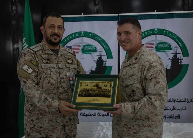 U.S. Marine Corps Col. Matt Hakola, right, Native Fury 22 Combined Exercise Coordination Cell co-director, U.S. Marine Corps Forces, Central Command, awards Col. Saud T. N. Al-Oqaily, CECC co-director, Saudi Armed Forces, a plaque during the closing ceremony for exercise Native Fury 22 at Yanbu Commercial Port, Kingdom of Saudi Arabia, Aug. 25, 2022. The U.S. and the Royal Kingdom of Saudi Arabia continue to enhance interoperability by providing regional stability and security while forward deployed in the U.S. Central Command area of responsibilities during Native Fury 22.