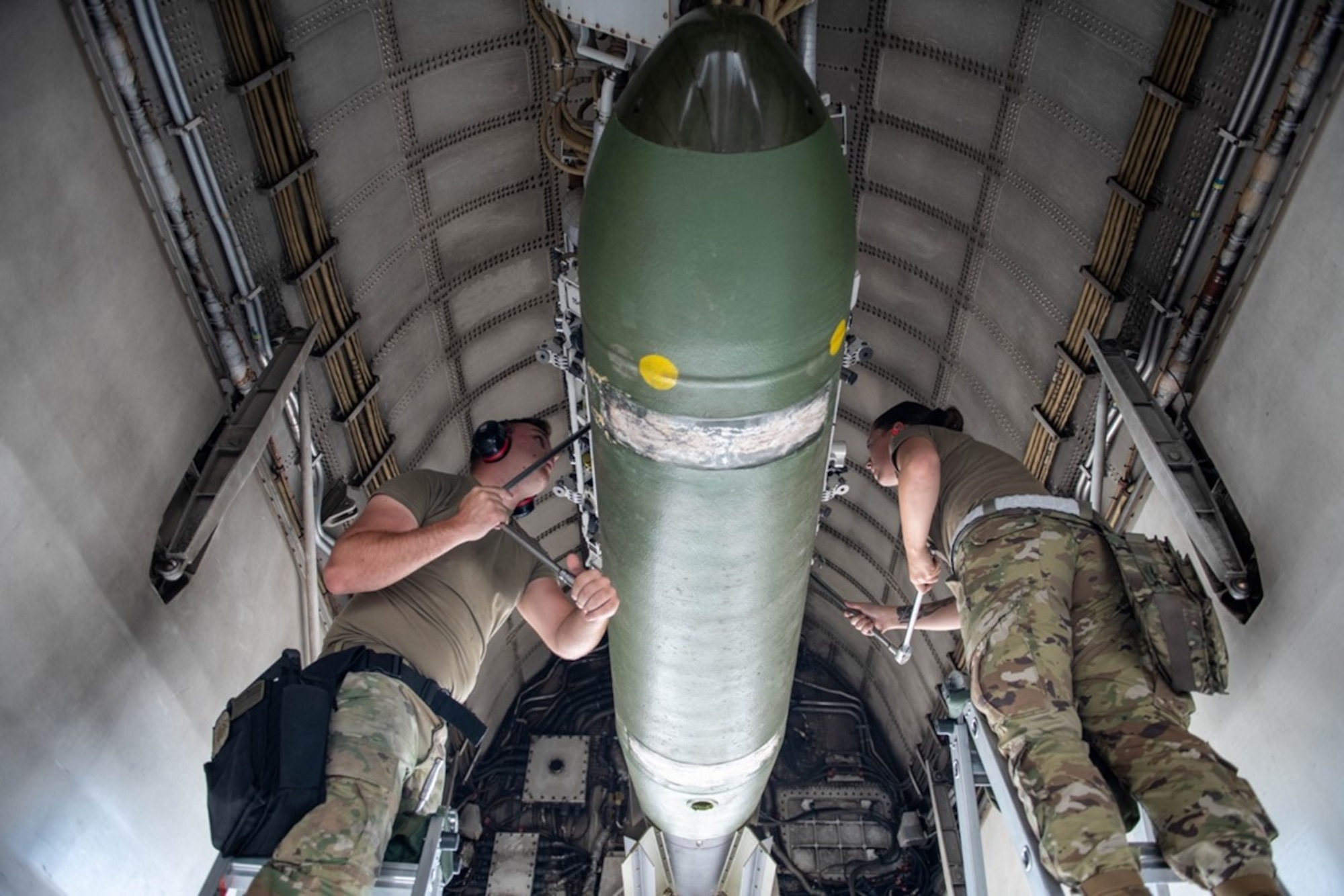 Staff Sgt. Shay Johnson, 28th Aircraft Maintenance Squadron load crew chief, and Senior Airman Makayla Singer, 28th AMXS  load crew member, attach a Mark-65 Quickstrike mine to a munitions rack at Ellsworth Air Force Base, S.D., Aug. 24, 2022.  The 28th Bomb Wing’s integration into the U.S. Navy live-fire mine exercise helped the Navy strengthen naval mine tactics, techniques, and procedures. (U.S. Air Force photo by Senior Airman Quentin K. Marx)