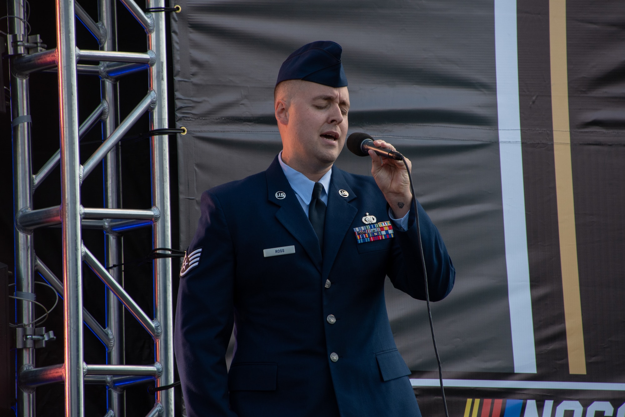 U.S. Air Force Staff Sgt. Alexander Ross, 509th Bomb Wing fuels systems NCO, sings the National Anthem during the NASCAR Hollywood Casino 400 at the Kansas Speedway in Kansas City, Kansas, Sept. 11, 2022. Whiteman Air Force Base Airmen supported pre-race festivities to represent the U.S. Air Force.(U.S. Air National Guard photo by Airman 1st Class Phoenix Lietch)