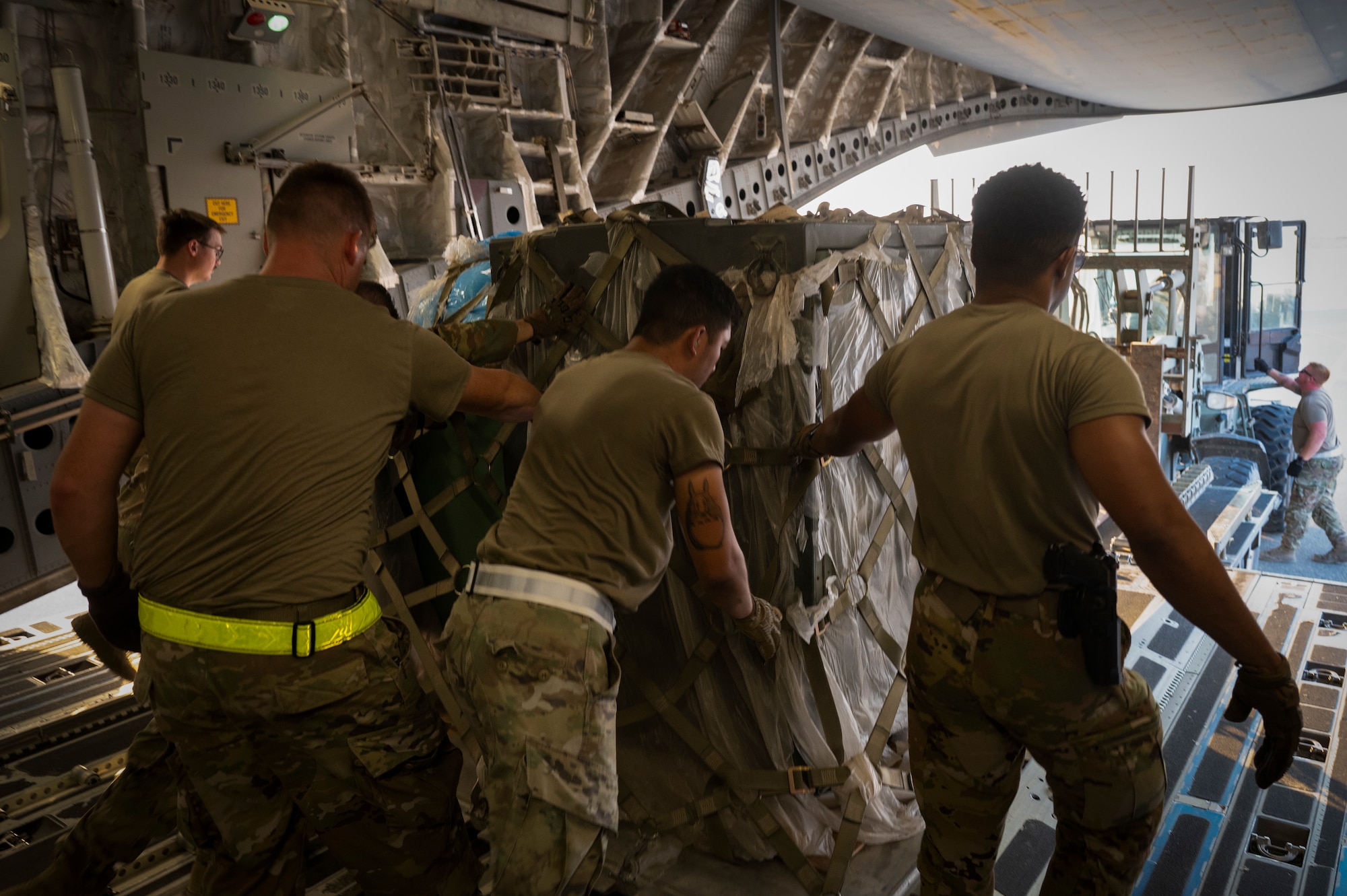 U.S. Air Force Airmen from the 386th Expeditionary Force Support Squadron and 386th Expeditionary Logistics Readiness Squadron work together to download supplies from a C-17 Globemaster III for Operation Agile Spartan III at an Undisclosed location, September 7, 2022. OAS III tested Ninth Air Force (Air Forces Central)’s ability to execute rapid troop and equipment movement to and from dispersed locations around the U.S. Central Command area of responsibility. (U.S. Air Force photo by Staff Sgt. Dalton Williams)