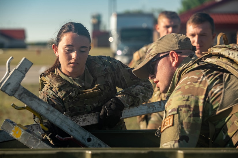 airmen unpack tent from container