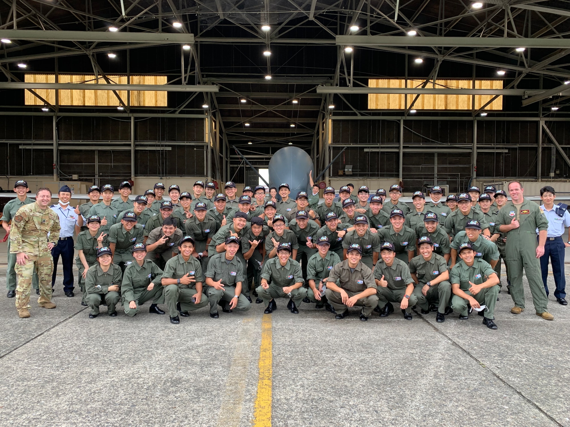 Japan National Defense Academy cadets and members of the 4th Reconnaissance Squadron from Andersen Air Base, Guam, pose for a group photo in front of a U.S. Air Force RQ-4 Global Hawk aircraft July 26 at Yokota Air Base, Japan. Japan recently purchased several Global Hawks under a foreign military sales program. (Courtesy photo)