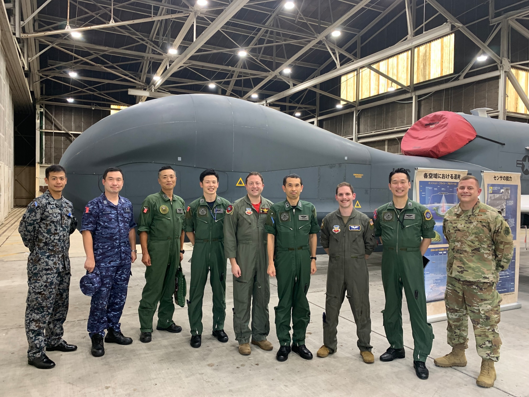 Members of Japan’s Air Defense Command A3/5, U.S. Air Force Brig. Gen. Jesse Friedel (right), 5th Air Force commander, and U.S. Air Force Lt. Col. John Wright (center), 4th Reconnaissance Squadron commander, stand in front of a U.S. Air Force RQ-4 Global Hawk remotely piloted surveillance aircraft July 22, 2022, at Yokota Air Base, Japan. The Japanese and American military leaders met to build a path to future allied success. (Courtesy photo)
