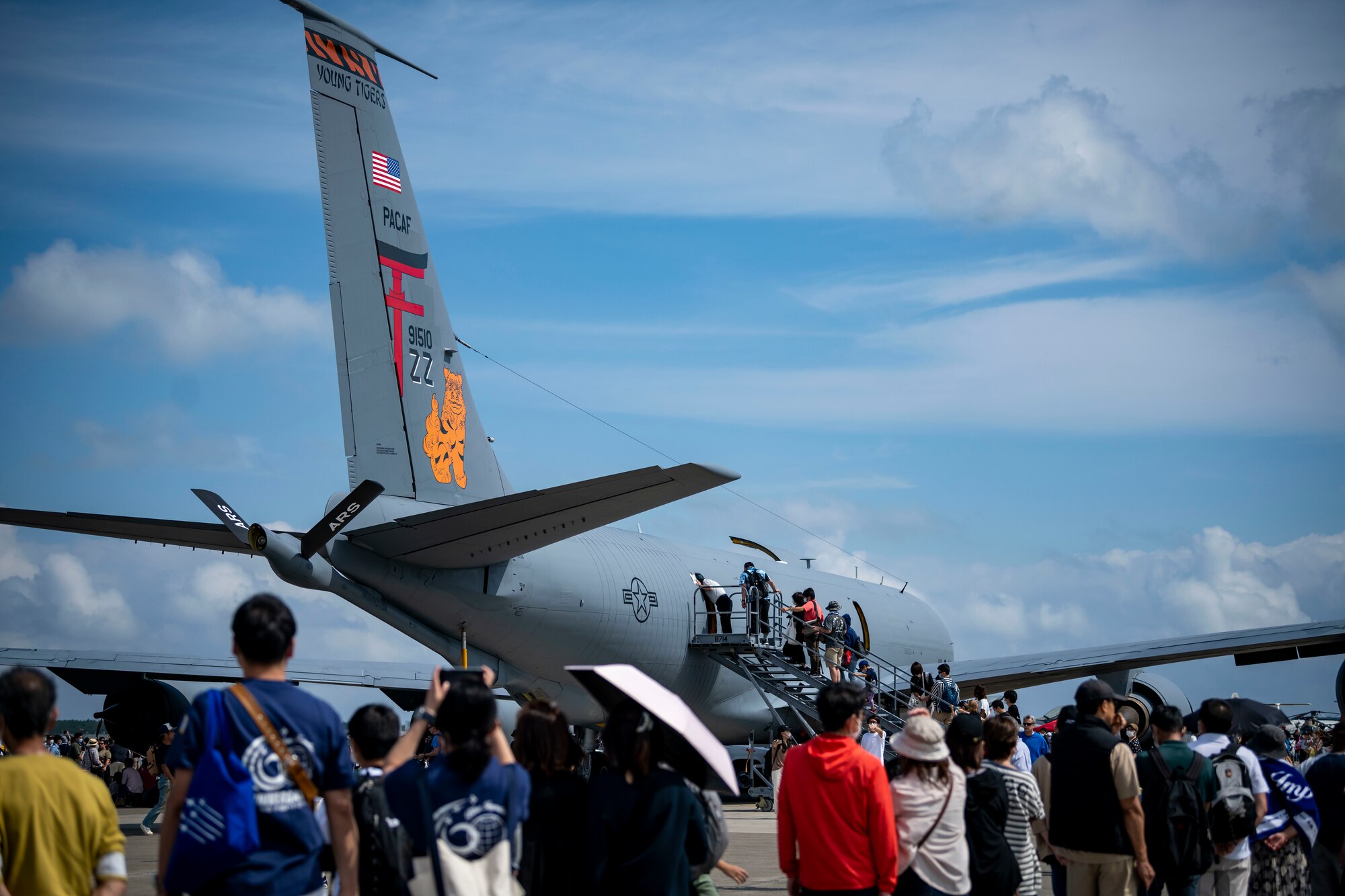 Attendees wait in line leading to an aircraft.