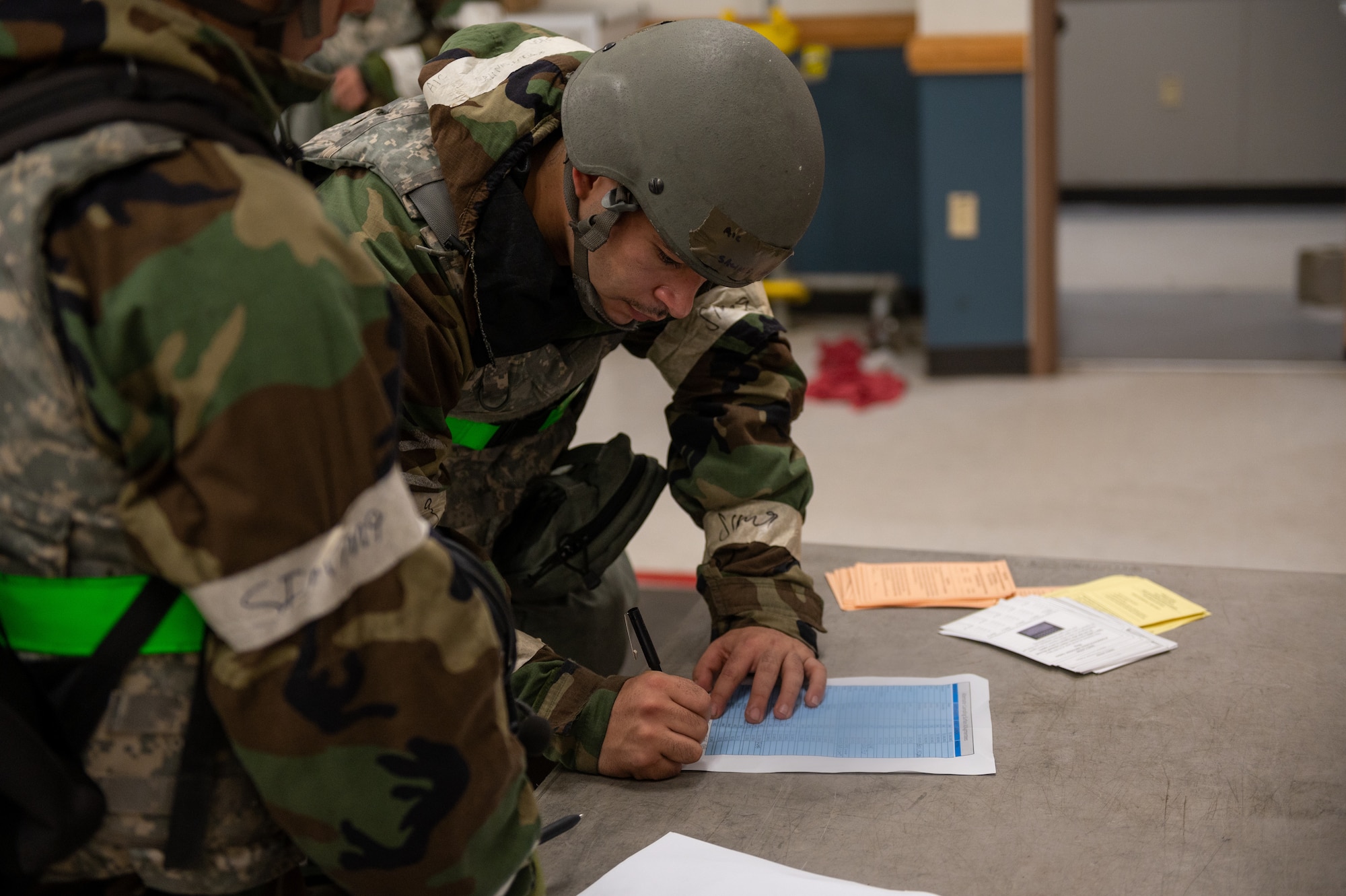 U.S. Air Force Airman 1st Class Enrique Salinas, 25th Fighter Generation Squadron avionics technician, signs-in during a 51st Security Forces Squadron augmentee recall as part of a base-wide training event