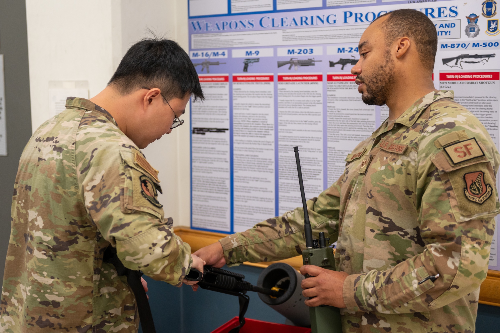 U.S. Air Force Senior Airman June Choi, 51st Medical Support Squadron medical records technician, clears an M-4 Carbine with the assistance of U.S. Air Force Staff Sgt. Cornell Nelson, 51st Security Forces Squadron (SFS) base defense operations center controller, during an augmentee recall