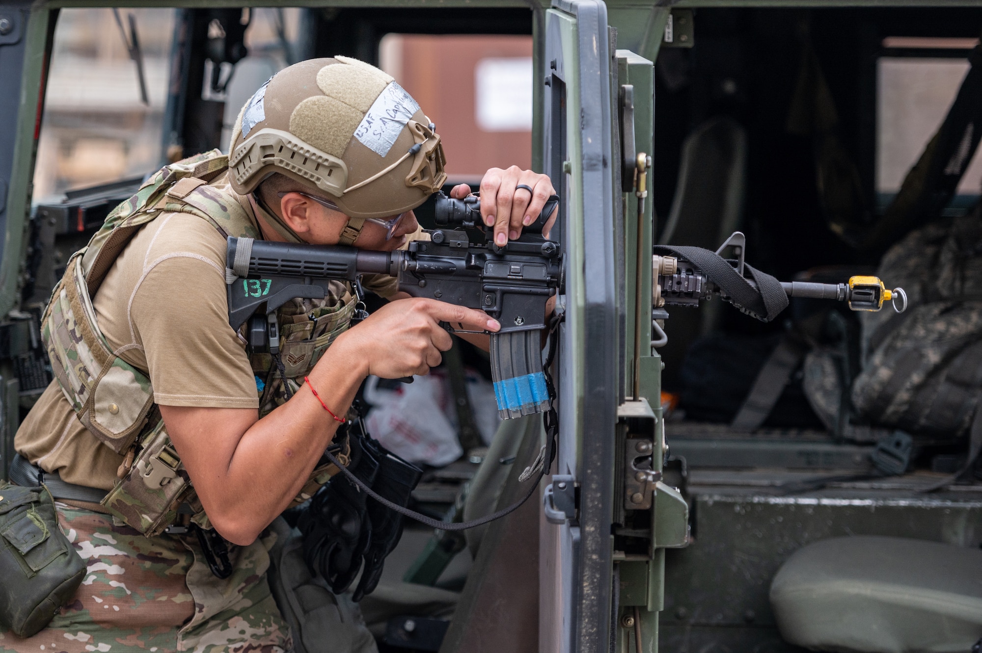 U.S. Air Force Senior Airman Justin Capulong, 51st Security Forces Squadron defender, braces his M4 Carbine against the door of a high mobility multipurpose wheeled vehicle during a training event