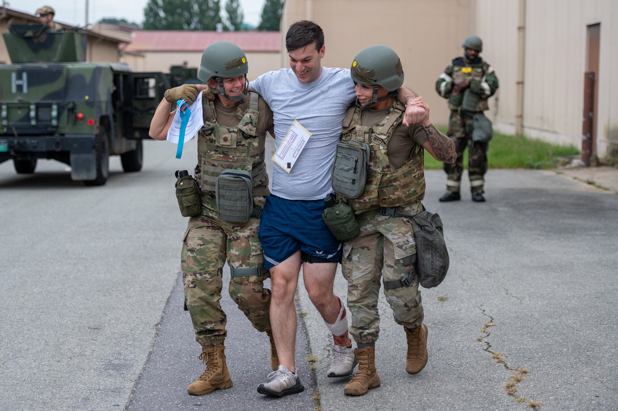 A simulated victim is assisted to a medical transport by members of the 51st Medical Group during a “Defend the Base” training scenario
