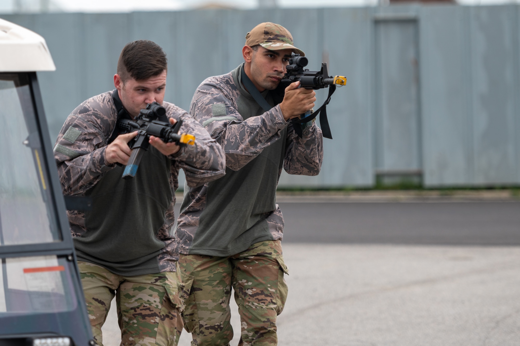 U.S. Air Force Tech. Sgt. David Bean and U.S. Air Force Airman 1st Class Marlon Perez, opposing forces (OPFOR) members, participate in a training scenario during a “Defend the Base” training event
