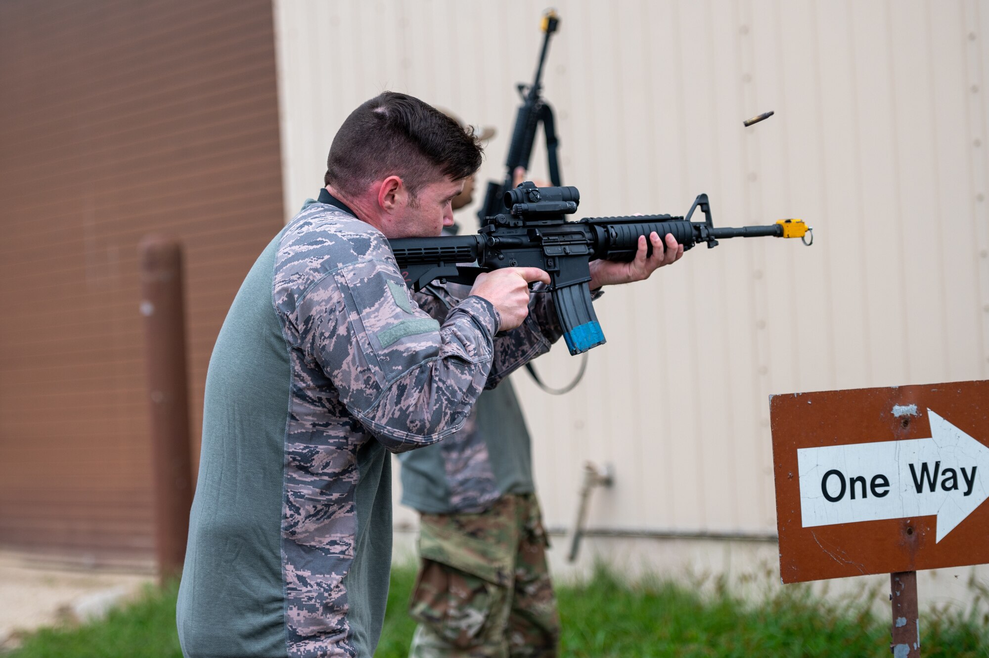 U.S. Air Force Tech. Sgt. David Bean, opposing forces (OPFOR) member, fires blank rounds during a “Defend the Base” training scenario