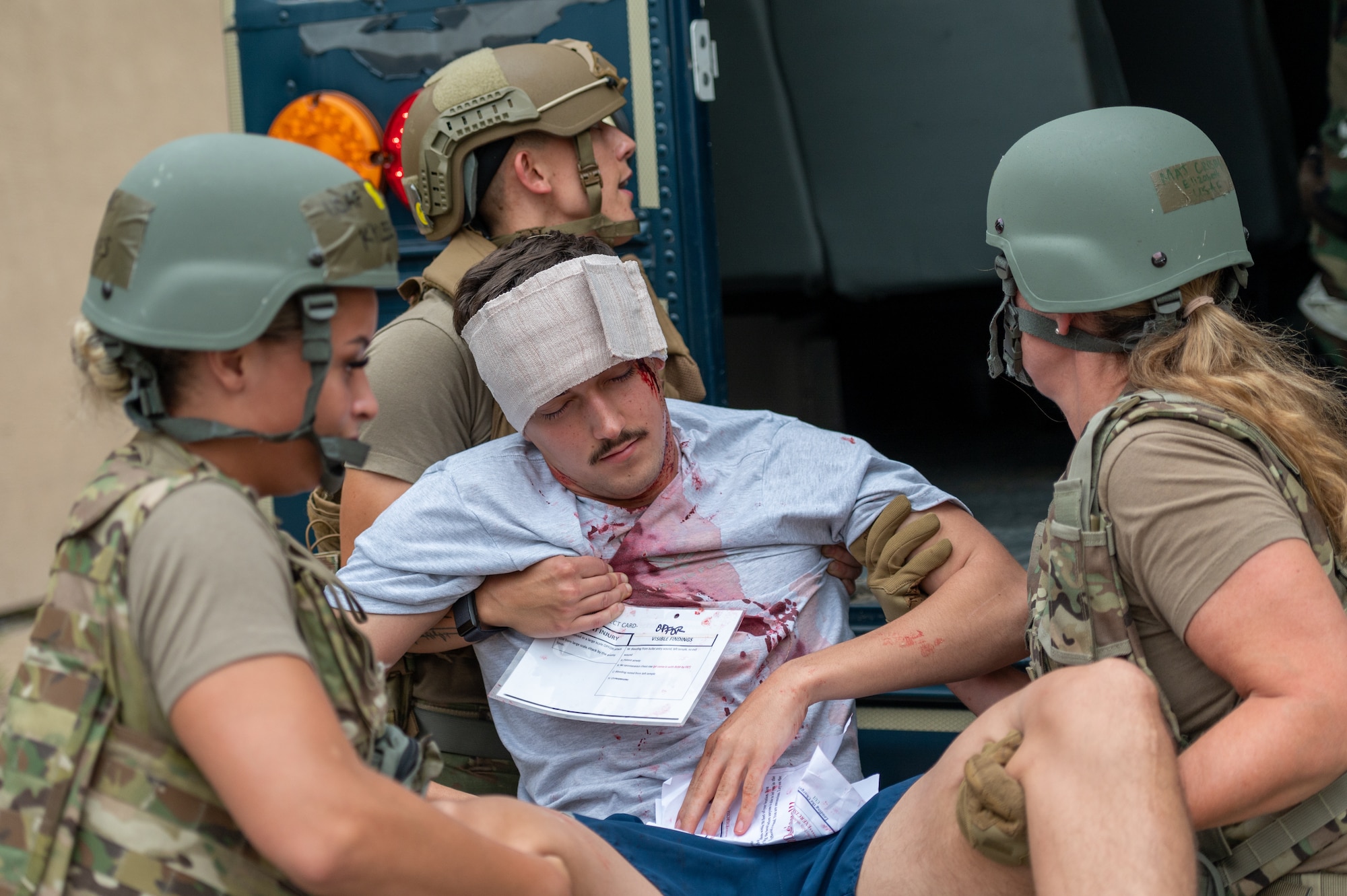 A simulated victim is lifted into the back of a transport vehicle by 51st Security Forces Squadron and 51st Medical Group members as part of a training event