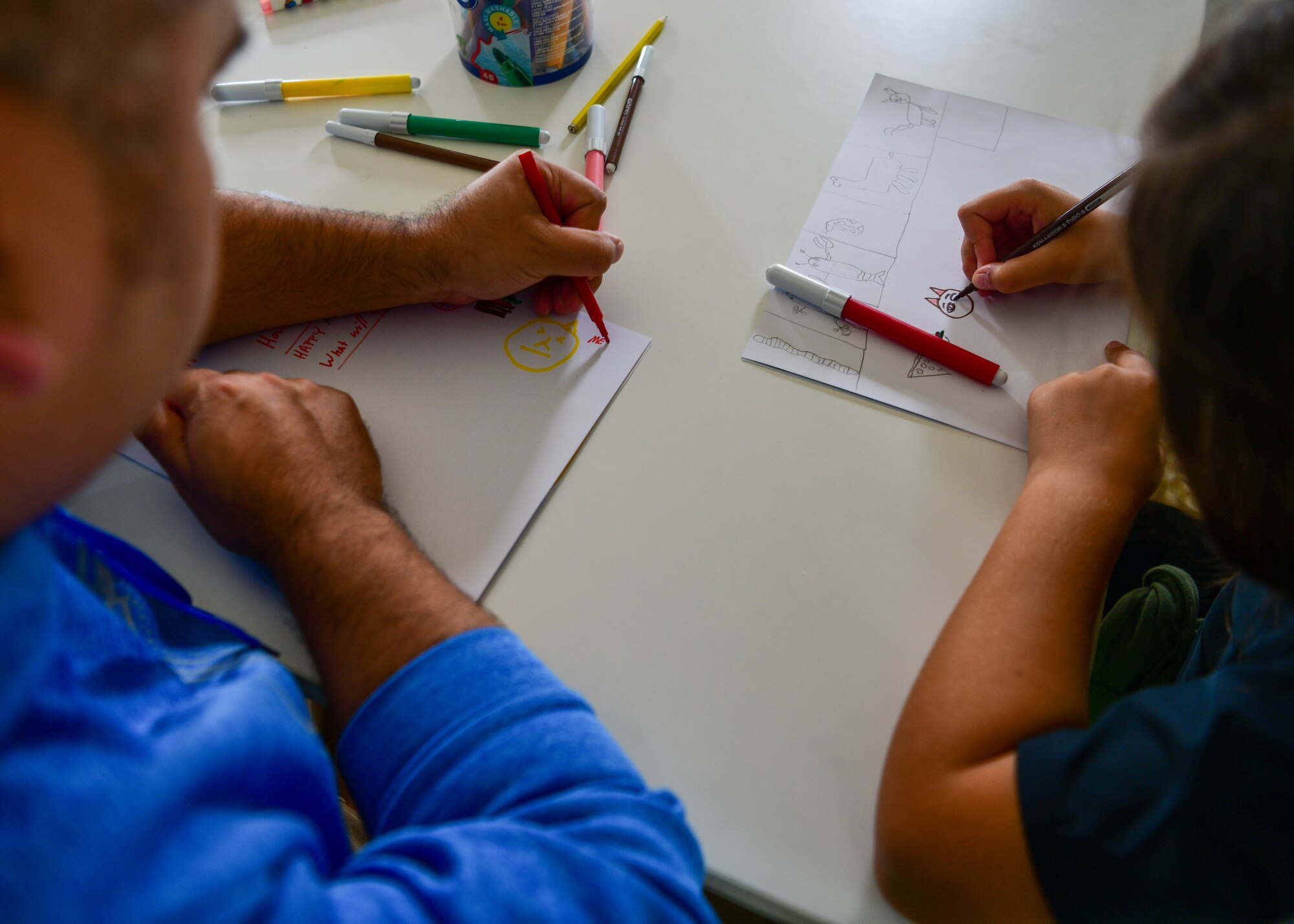 Tech. Sgt. Juan Hernandez, Vicini Americani English Teaching Program volunteer, draws a picture with an Italian child project at the Giovani in Movimento summer camp in Aviano, Italy, Aug. 31, 2022. The summer camps took place July 4-29 in Polcenigo, Italy, and August 29 through September 9 in Aviano, Italy. (U.S. Air Force photo by Senior Airman Brooke Moeder)