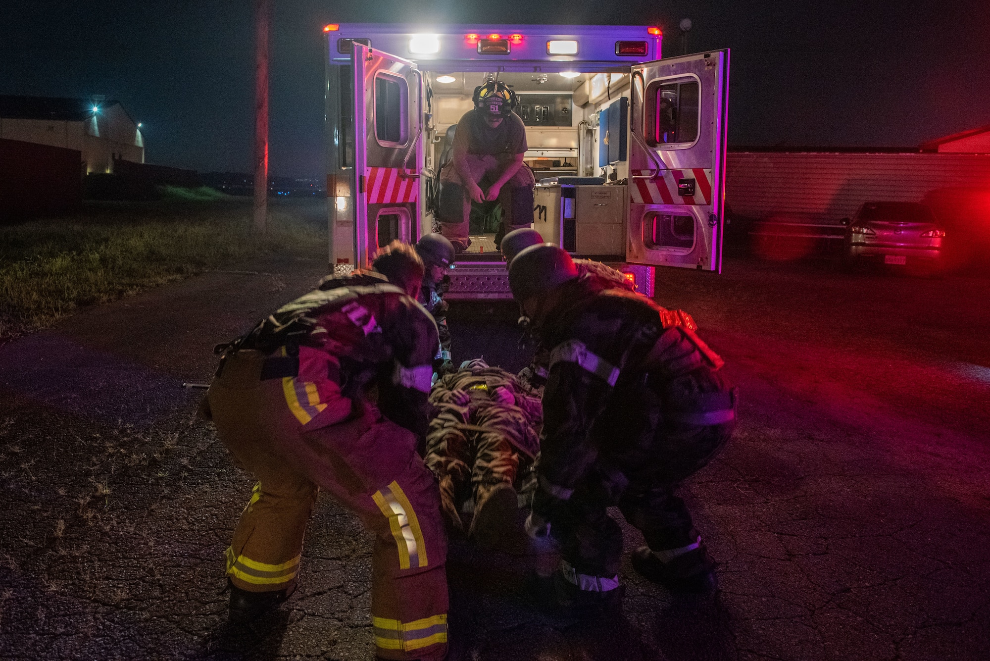 Firefighters assigned to the 51st Civil Engineer Squadron and field response team members, begin to lift a simulated victim into an ambulance during a fire response scenario at Osan Air Base, Republic of Korea, Sept. 12, 2022, in support of a wing training event.