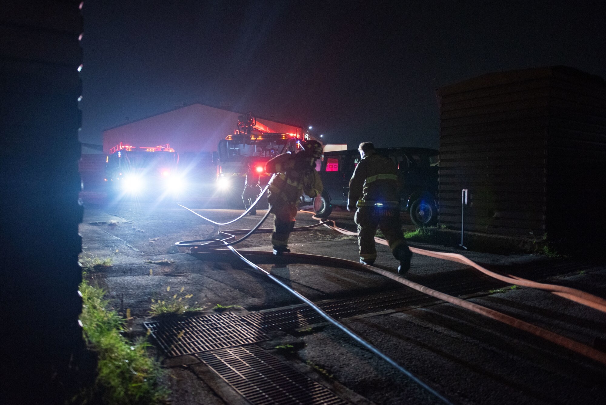 U.S Air Force Staff Sgt. Benny Bowen and U.S. Air Force Senior Airman Jacob Jenkins, 51st Civil Engineer Squadron lead firefighters, set up hoses during a fire response scenario at Osan Air Base, Republic of Korea, Sept. 12, 2022, in support of a wing training event.