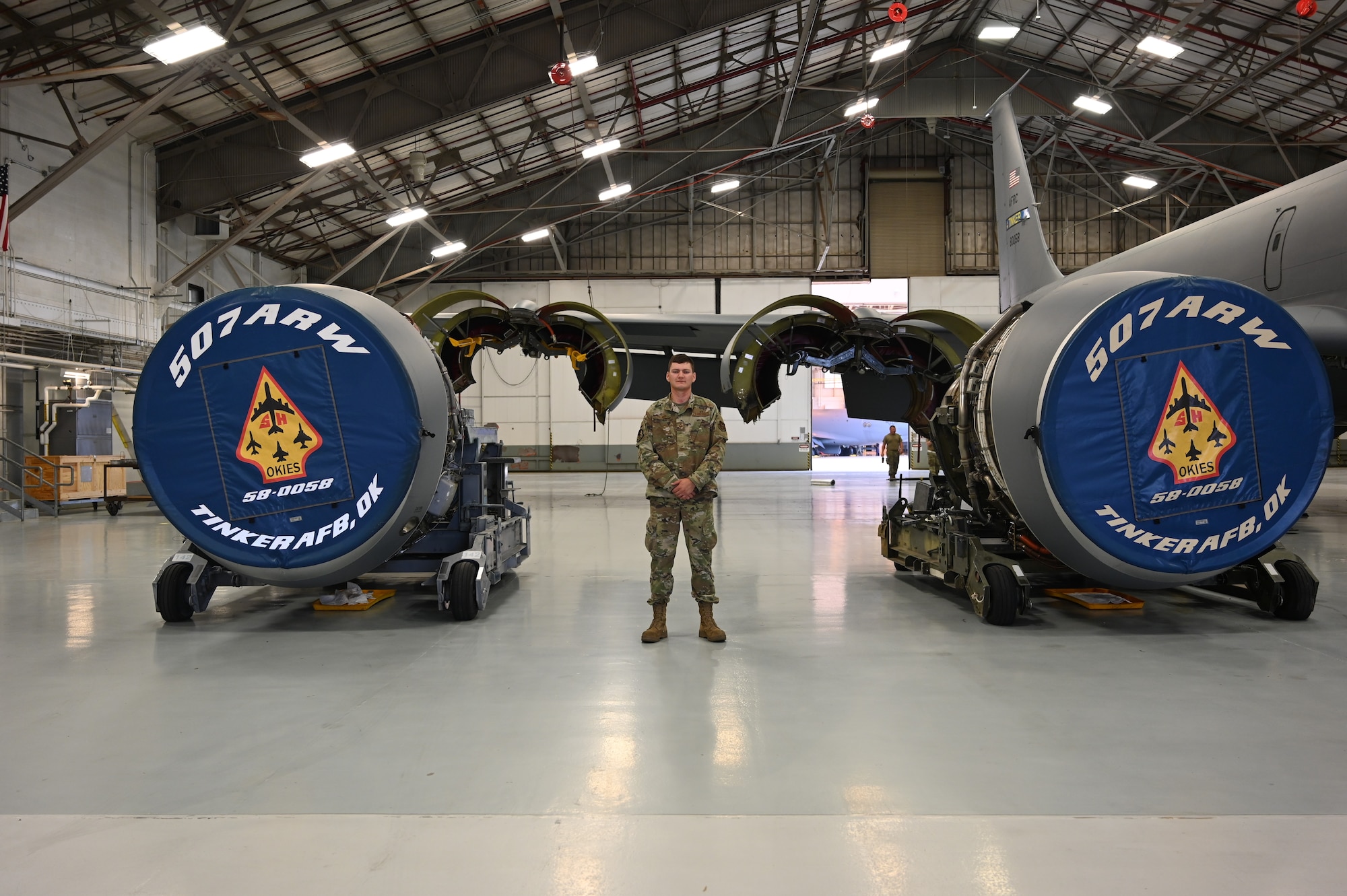 an airman standing between two plane engines