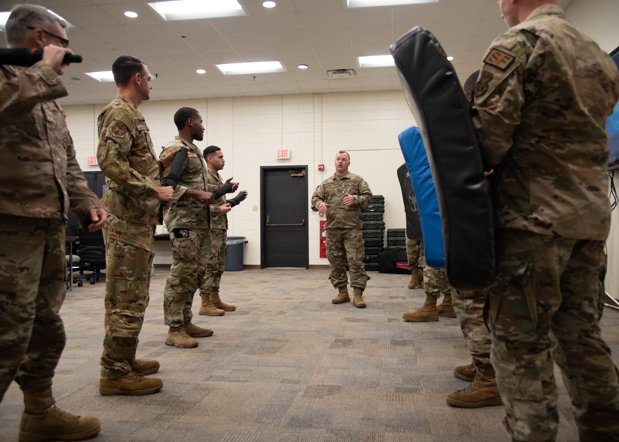 Airmen in two rows listen as another Airman between the rows instructs
