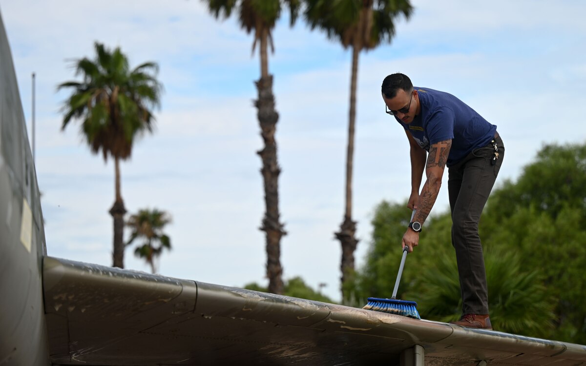 A photo of a man washing a plane.