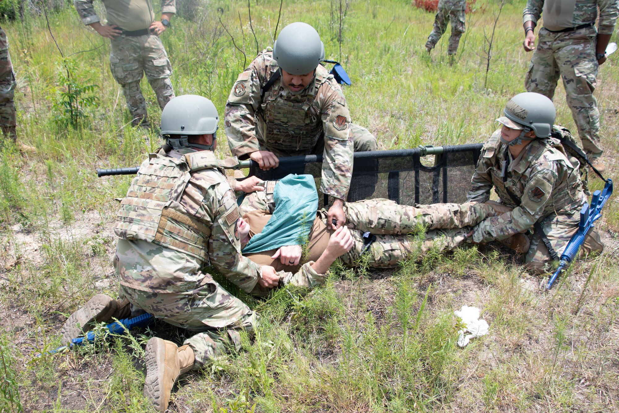 Members with the 221st and 239th Combat Communications Squadrons practice Tactical Combat Casualty Care maneuvers during Exercise BUMBU 22 at Camp Shelby, Mississippi, June 9, 2022. BUMBU 22 is a training exercise involving five geographically-separated combat communications squadrons from across the 254th Combat Communications Group. (U.S. Air National Guard photo by Staff Sgt. Adrian Brakeley)