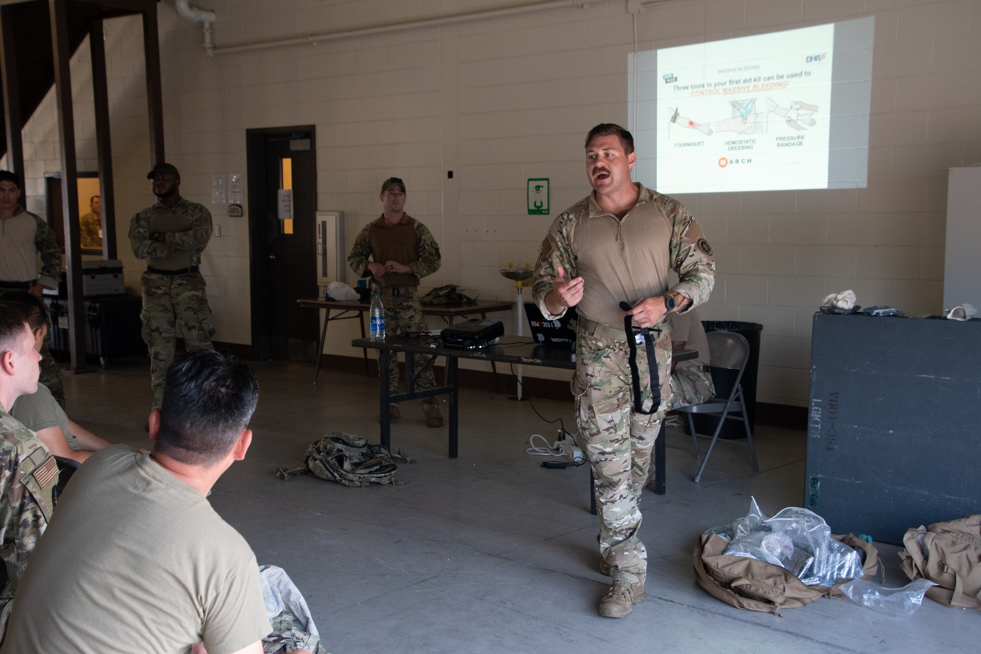Members with the 221st and 239th Combat Communications Squadrons receive instruction on Tactical Combat Casualty Care from Staff Sgt. Travis Wilson, 159th Fighter Wing, during Exercise BUMBU 22 at Camp Shelby, Mississippi, June 9, 2022. BUMBU 22 is a training exercise involving five geographically-separated combat communications squadrons from across the 254th Combat Communications Group. (U.S. Air National Guard photo by Airman 1st Class Kelly Ferguson)