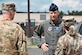 Maj. Gen. Corey Martin speaks to two airmen outside