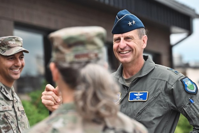 Maj. Gen. Corey Martin speaks to two airmen