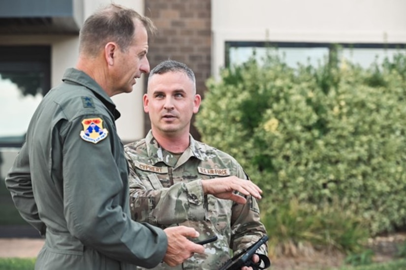 Two airmen speak to each other outside