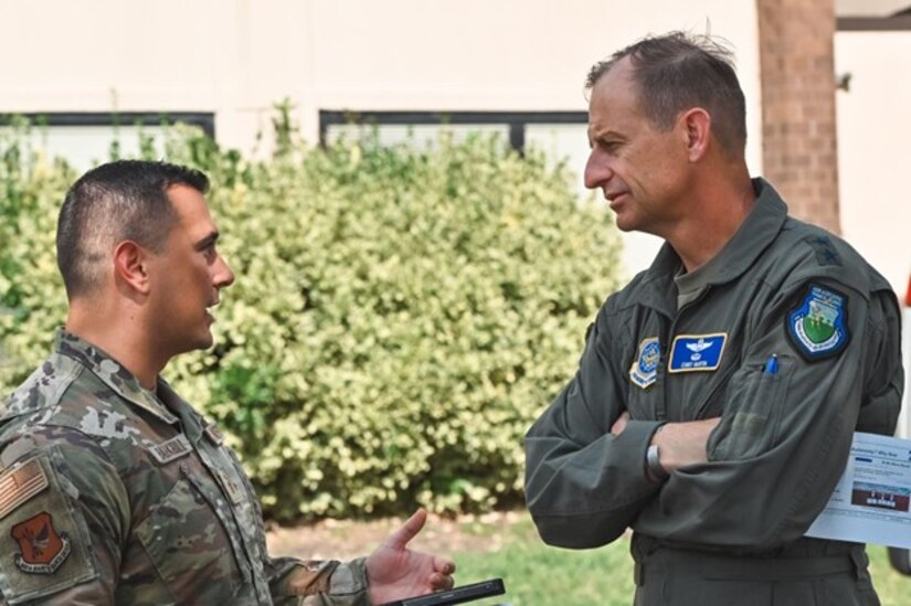 Two airmen speak to each other outdoors