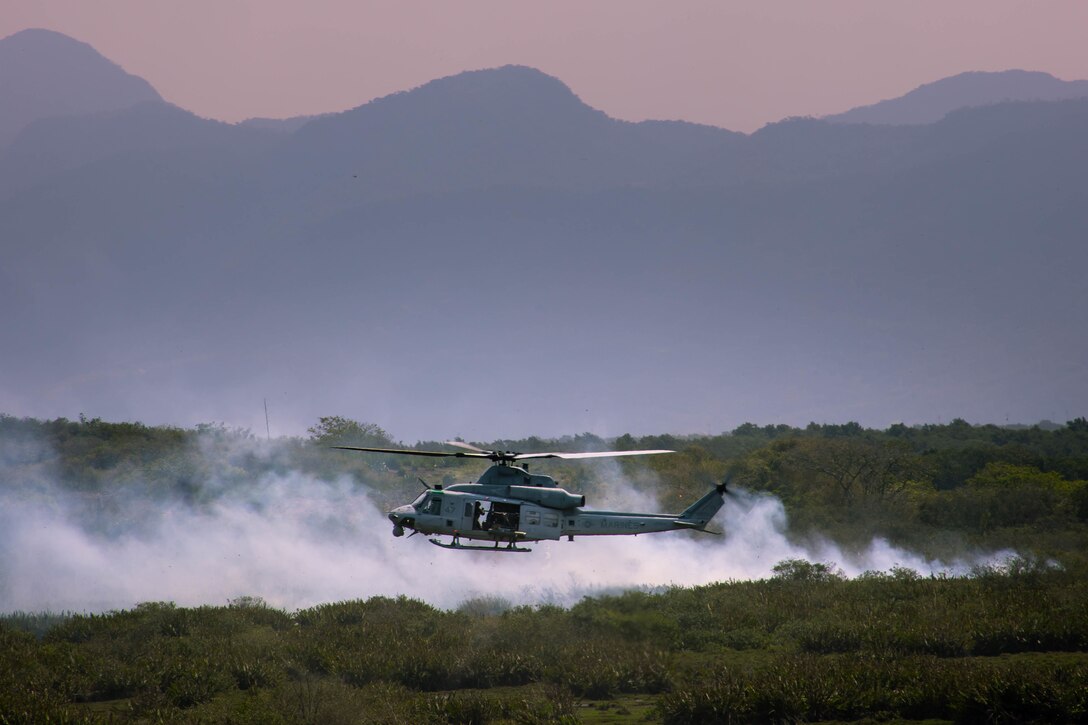 A UH-1Y Venom helicopter, attached to Marine Light Attack Helicopter Squadron (HMLA) 773, 4th Marine Aircraft Wing, Marine Forces Reserve, in support of Special Purpose Marine Air-Ground Task Force UNITAS LXIII, fires a crew-served weapon during close air support drills as part of exercise UNITAS LXIII at Santa Cruz Air Force Base, Rio de Janeiro, Sept. 8, 2022. HMLA 773 and 4th Air Naval Gunfire Liaison Company cross trained with the Brazilian Marine Corps by conducting close air support drills, which consists of locating targets from the ground and relaying coordinates to assets in the sky to destroy. UNITAS trains forces to conduct joint maritime operations through the execution of anti-surface, anti-submarine, anti-air, amphibious and electronic warfare operations that enhance warfighting proficiency and increase interoperability among participating naval and marine forces. (U.S. Marine Corps photo by Cpl. Colton K. Garrett)