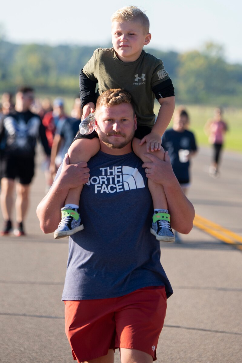 Jon Taylor, Air Force Materiel Command headquarters, and his son, Maverick, 5, take part in the 2-kilometer walk portion of Run for the Fallen on Sept. 9, 2022, at Wright-Patterson Air Force Base, Ohio. Taylor said it was important for his son to know about the terrorist attacks. (U.S. Air Force photo by R.J. Oriez)