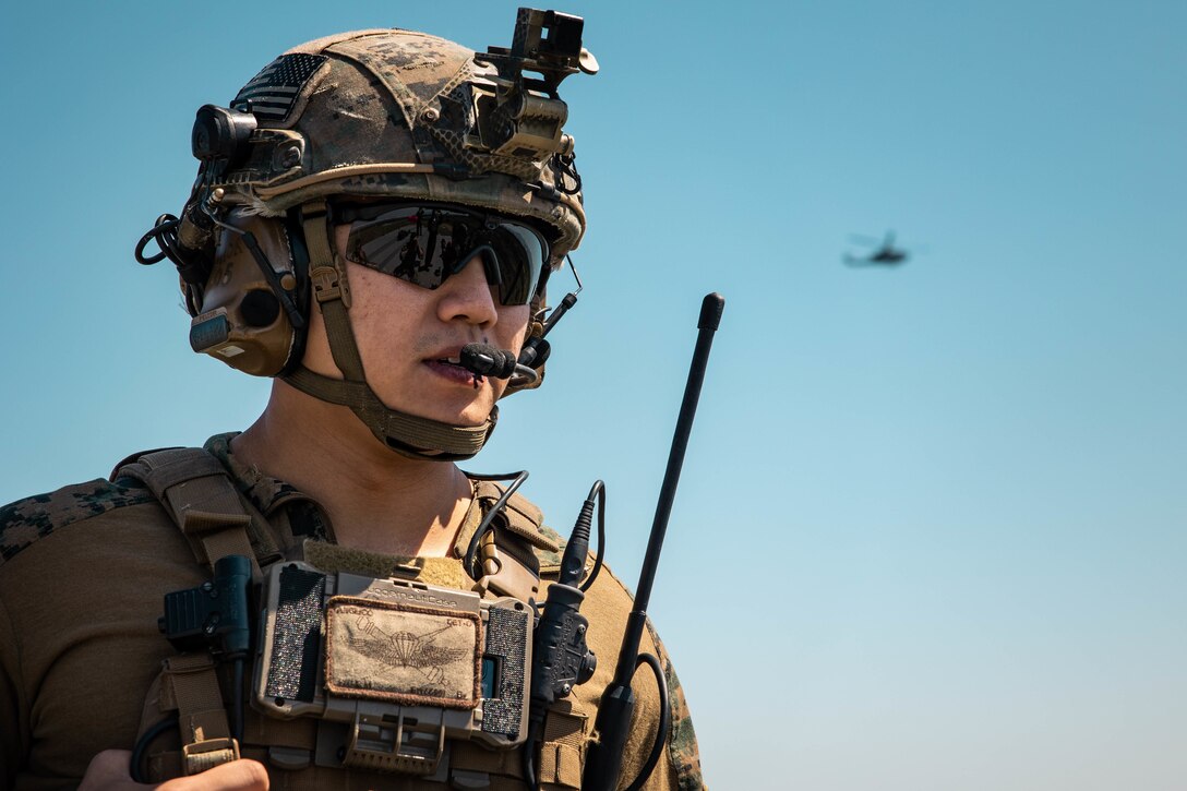 U.S. Marine Corps Sgt. Brian Wu, a joint terminal attack controller with 4th Air Naval Gunfire Liaison Company, Marine Forces Reserve, in support of Special Purpose Marine Air-Ground Task Force UNITAS LXIII, monitors his headset during close air support drills as part of exercise UNITAS LXIII at Santa Cruz Air Force Base, Rio de Janeiro, Sept. 8, 2022. Light Attack Helicopter Squadron (HLMA) 773 and 4th ANGLICO cross trained with the Brazilian Marine Corps by conducting close air support drills, which consists of locating targets from the ground and relaying coordinates to assets in the sky to destroy. UNITAS trains forces to conduct joint maritime operations through the execution of anti-surface, anti-submarine, anti-air, amphibious and electronic warfare operations that enhance warfighting proficiency and increase interoperability among participating naval and marine forces. Wu is a native of Miami, FL. (U.S. Marine Corps photo by Cpl. Colton K. Garrett)
