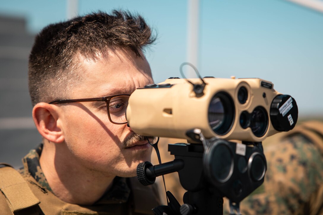 U.S. Marine Corps Lance Cpl. Robert Furton, a forward observer with 4th Air Naval Gunfire Liaison Company, Marine Forces Reserve, in support of Special Purpose Marine Air-Ground Task Force UNITAS LXIII, looks through a common laser range finder during close air support drills as part of exercise UNITAS LXIII at Santa Cruz Air Force Base, Rio de Janeiro, Sept. 8, 2022. Light Attack Helicopter Squadron (HMLA) 773 and 4th ANGLICO cross trained with the Brazilian Marine Corps by conducting close air support drills, which consists of locating targets from the ground and relaying coordinates to assets in the sky to destroy. UNITAS trains forces to conduct joint maritime operations through the execution of anti-surface, anti-submarine, anti-air, amphibious and electronic warfare operations that enhance warfighting proficiency and increase interoperability among participating naval and marine forces. (U.S. Marine Corps photo by Cpl. Colton K. Garrett)