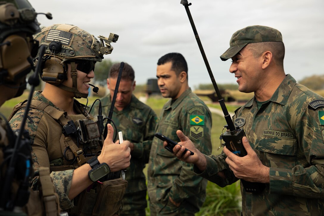 U.S. Marine Corps Sgt. Brian Wu, left, with 4th Air Naval Gunfire Liaison Company, Marine Forces Reserve, in support of Special Purpose Marine Air-Ground Task Force UNITAS LXIII, gives a thumbs up to Terceio-Sargento (Sergeant Brazilian Marine Corps) Igor Aleixo, a forward observer with the Brazilian Marine Corps, during call for fire drills as part of exercise UNITAS LXIII at São Pedro da Aldeia, Brazil, Sept. 5, 2022. Marine Light Attack Helicopter Squadron (HMLA) 773 and 4th ANGLICO cross trained with the Brazilian Marine Corps by conducting simulated close air support drills, which consists of locating targets from the ground and relaying coordinates to assets in the sky to destroy. UNITAS trains forces to conduct joint maritime operations through the execution of anti-surface, anti-submarine, anti-air, amphibious and electronic warfare operations that enhance warfighting proficiency and increase interoperability among participating naval and marine forces. (U.S. Marine Corps photo by Cpl. Colton K. Garrett)