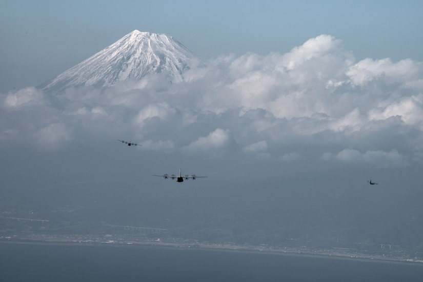 U.S. Air Force cargo planes skirt a mountain.