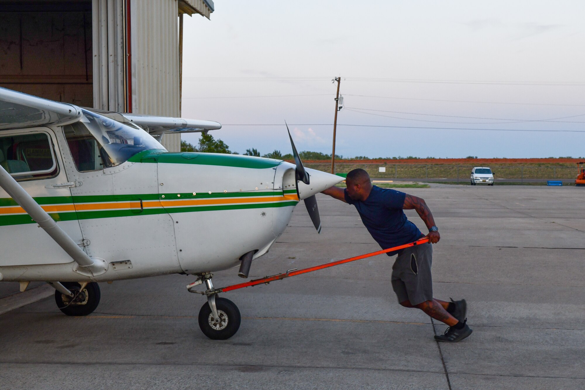 U.S. Air Force 2nd. Lt. Bryan Lee, 54th Air Refueling Squadron KC-135 Stratotanker student pilot, rolls a plane back into a hangar after taking it out for a flight in Altus, Oklahoma, on August 26, 2022. Lee was a boom operator instructor at Altus Air Force Base, Oklahoma from 2017 to 2018. (U.S. Air Force photo by Airman 1st Class Kari Degraffenreed)