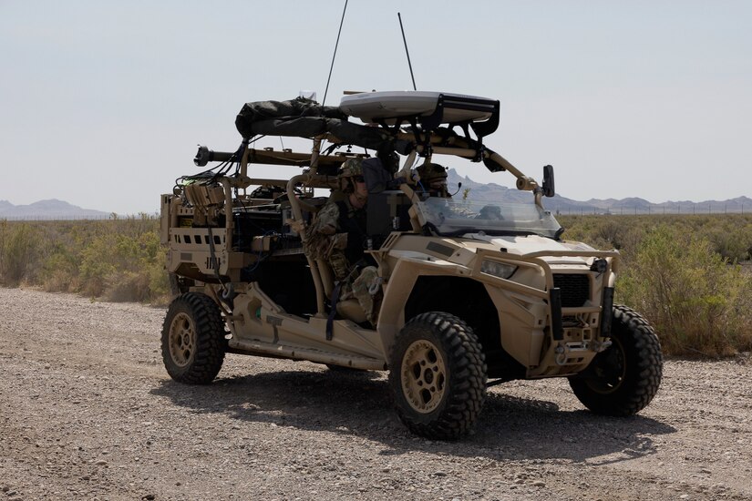 Two soldiers ride in a MRZR razors in the desert.