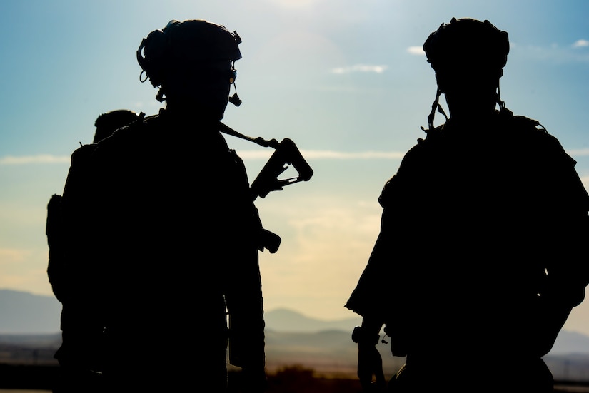 Two soldiers are silhouetted by the sunlight
