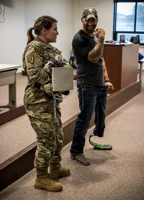 Maj. Valerie Brown, the 75th Innovation Command's Talent Management Program Manager, holds a cinderblock while Earl Granville, an Operation Enduring Freedom veteran and amputee, explains the importance of not holding all of life's burdens on one's own, during a resilience class at the 75th Innovation Command Headquarters.